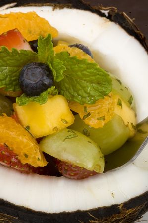 Tropical, minty, fruit salad served in a coconut shell with honey yogurt on the side.