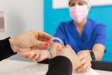 Hands holding invisible orthodontics at the dental clinic