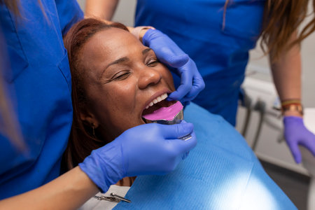 Close up of a dentists hands placing an impression tray at the dental clinic
