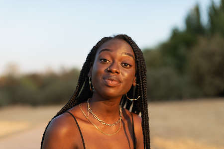 Close-up portrait of a young black female expressively looking at camera in the parkの写真素材