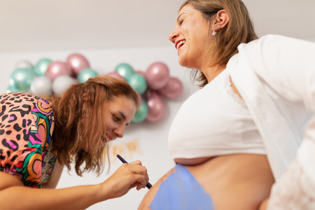 Bodypainting artist painting over a happy pregnant womans bellyの写真素材