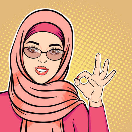 Pop art happy arab woman in hijab smiling and showing ok sign, vector illustration of successful muslim woman in retro comic styleのイラスト素材