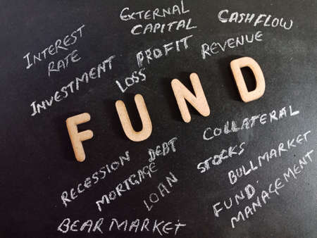 Fund word presented on chalk board with wooden alphabets collection on black educational background.の写真素材