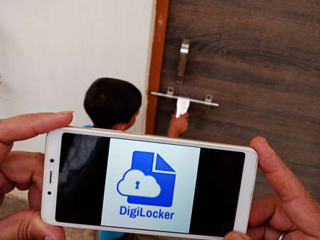 District Katni, Madhya Pradesh, India - 23 May 2020: Digi locker displayed on smart phone screen by hand holding mobile concept at open background.のeditorial素材