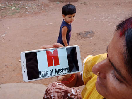 DISTRICT KATNI, INDIA - JUNE 02, 2020: An indian woman holding smart phone with displaying Bank of...