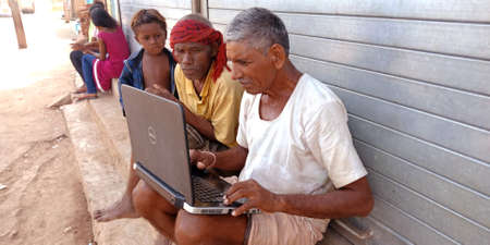 DISTRICT KATNI, INDIA - OCTOBER 23, 2019: Group of indian village peoples working on laptop at open area background, concept for digital learning technology awareness.のeditorial素材