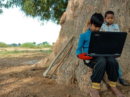 DISTRICT KATNI, INDIA - JANUARY 01, 2020: Two indian boys learning together about laptop technology...