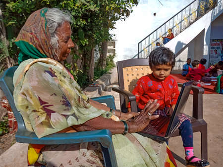 DISTRICT KATNI, INDIA - JANUARY 13, 2020: An indian village old woman operating laptop computer with...