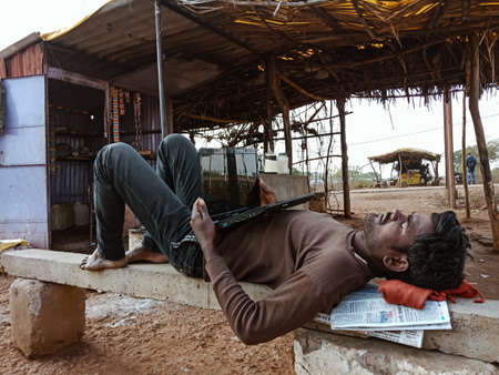 DISTRICT KATNI, INDIA - JANUARY 01, 2020: An indian village man sleeping with keeping laptop on...