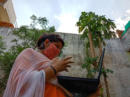 DISTRICT KATNI, INDIA - MAY 16, 2020: An indian office girl operating laptop technology at home also...