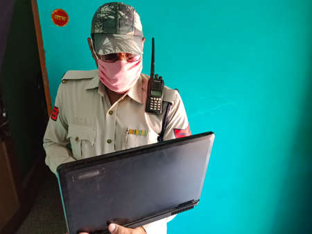 DISTRICT KATNI, INDIA - MAY 21, 2020: An indian police head constable working on laptop at home,...