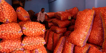 DISTRICT KATNI, INDIA - AUGUST 07, 2019: A labour working around potato stocks at Fresh green vegetable street market at village distribution area.のeditorial素材