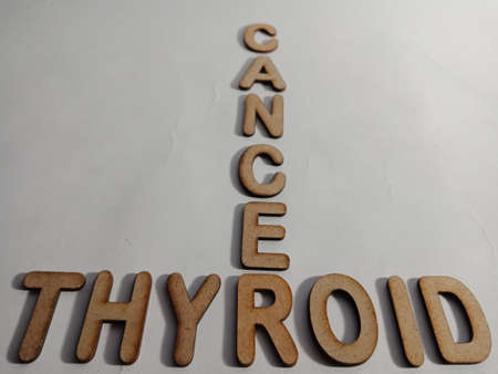 Thyroid cancer word display with cross wooden alphabet concept for informational awareness.