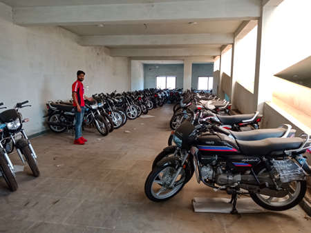 DISTRICT KATNI, INDIA - JANUARY 29, 2020: An Asian Sales executive officer displaying latest Sport bike model at Hero automobile motorcycle godown.のeditorial素材