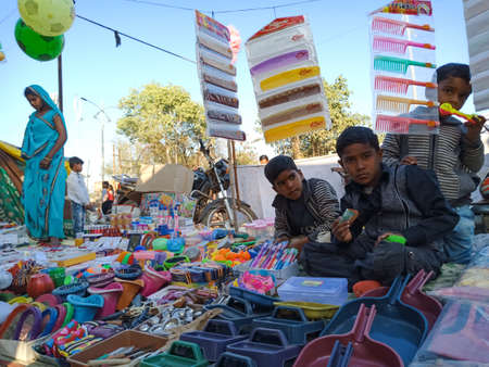 DISTRICT KATNI, INDIA - FEBRUARY 02, 2020: Indian village kids selling toys at street poor market during hindu traditional festival summer fest event.のeditorial素材