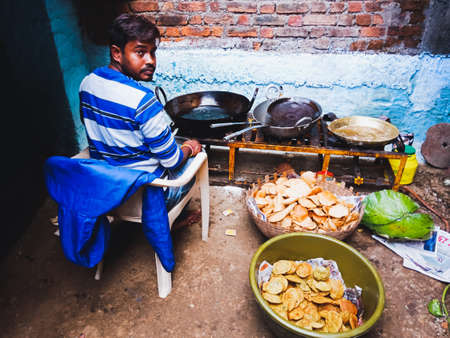 DISTRICT KATNI, INDIA - OCTOBER 06, 2019: An indian poor male chef frying puri for festival food...