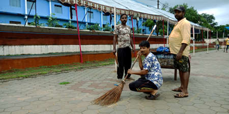 DISTRICT KATNI, INDIA - AUGUST 12, 2019: Indian Municipality male sweepers cleaning street for independence day program at parade ground.のeditorial素材