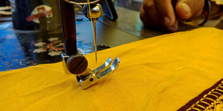 DISTRICT KATNI, INDIA - SEPTEMBER 18, 2019: Needle stitching cloth from sewing machine on road side at outdoor environment.のeditorial素材