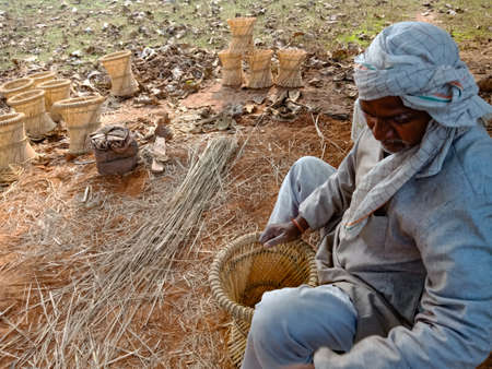DISTRICT KATNI, INDIA - JANUARY 18, 2020: An indian muslim man making dry grass made chair on open...
