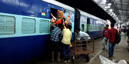 DISTRICT KATNI, INDIA - OCTOBER 04, 2019: Boys group efforts for Lord durga statue a holy god art transporting via indian train transport service from railway station.のeditorial素材
