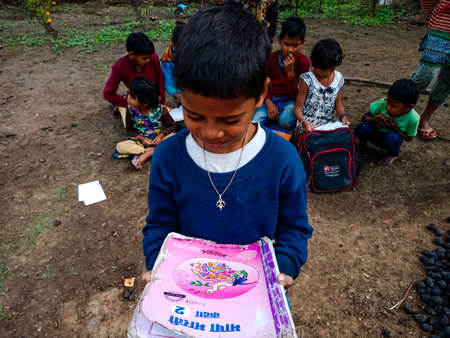 DISTRICT KATNI, INDIA - JANUARY 01, 2020: An Indian school poor boy reading hindi medium book at...