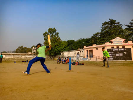 DISTRICT KATNI, INDIA - DECEMBER 02, 2019: Indian jio company staff people playing cricket together at forester playground around beautiful sky field.のeditorial素材