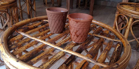 kulhad tea kept on wooden bamboo chair at local beverage shop.