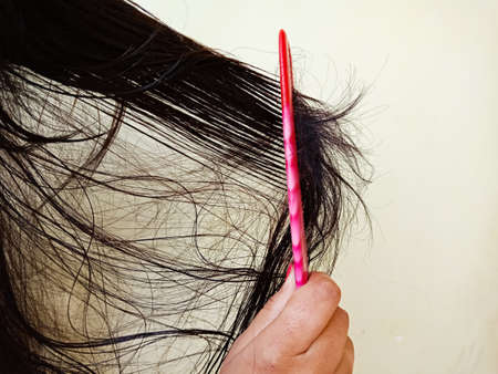 An indian girl combing hair isolated with text space, fallen black hair concept.