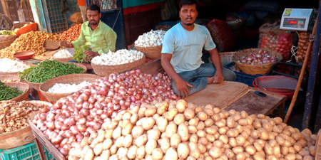 DISTRICT KATNI, INDIA - OCTOBER 13, 2019: An indian village greengrocer selling fresh potatoes and onions at vegetable market in asian street.のeditorial素材