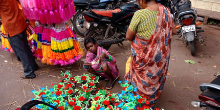 DISTRICT KATNI, INDIA - OCTOBER 19, 2019: Asian poor ladies selling flower made item during hindu...