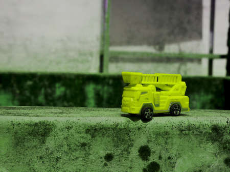 Yellow color fire truck toy presented on cemented surface for commercial image
