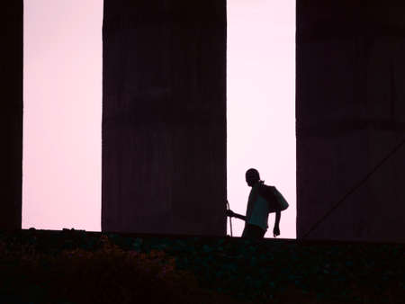Man going on center frame with blur around railway bridge architectureの写真素材