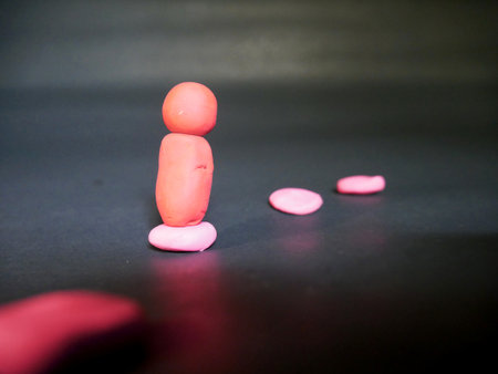 Man without hand clay standing on chips on silver backgroundの写真素材