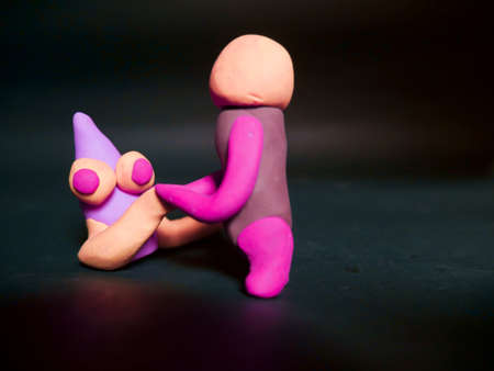 Man with creature clay cartoon shaking hands together on dark backgroundの写真素材