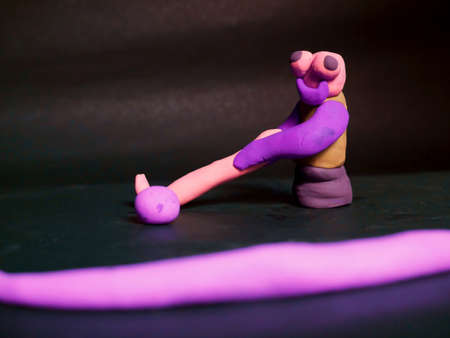 Clay man cartoon playing hockey hitting ball towards blur finish lineの写真素材