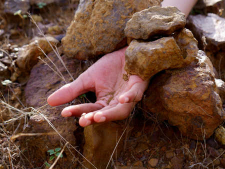 Boy hand presented down the stone rocks, land slide concept.の写真素材