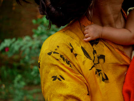 Mother carried baby on lap, lovely motherhood image.の写真素材