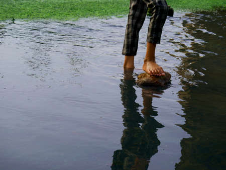 Kid leg with shadow on water reflection nature presentation for children lifestyle concept.の写真素材