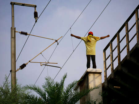 Man alone standing upon bridge, spreading both hand boy lifestyle concept.