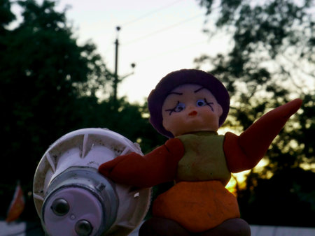 Toy doll holding led electric bulb on natural sunset background.の写真素材