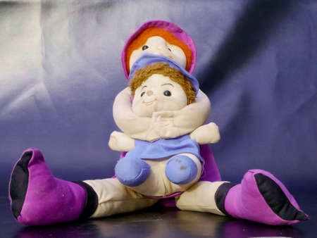 Two soft toy dolls presented together isolate on gray background, kids playing object imageの写真素材