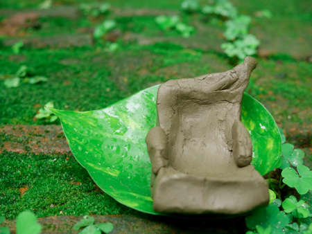 Soil made sitting chair crafted and presented green leaf around natural background.の写真素材
