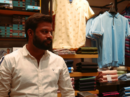 DISTRICT KATNI, INDIA - MARCH 02, 2022: An indian male with beard sitting at counter of men fashion casual cloth showroom.のeditorial素材
