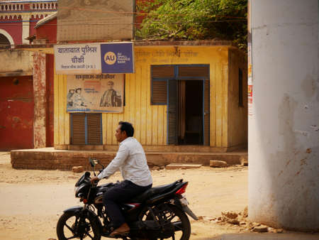 An indian motor bike rider going infront of traffic police station on road at city Katni Madhya...