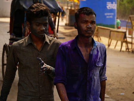 Two unidentified indian boys coming on road after playing holi festival in india, face color people lifestyle on festival season at city Katni Madhya Pradesh in India on March 2022.のeditorial素材