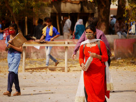 unidentified asian female school student wearing face mask for covid infection protection at school...