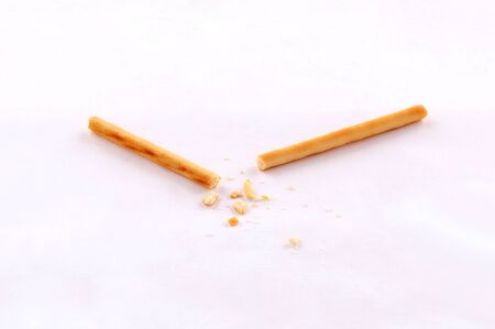 broken salty bread stick crumbs on white background isolated