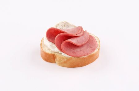 spread white cheese herb with salami on baguette slice canape isolated on white backgroundの写真素材