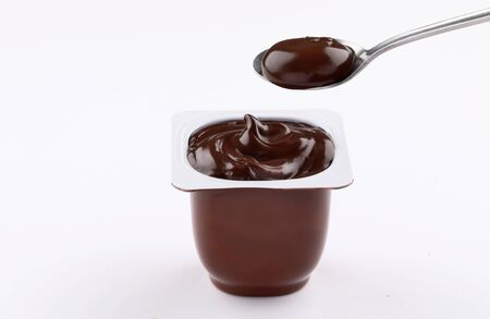 chocolate pudding brown cup plastic  with spoon isolated on white backgroundの写真素材