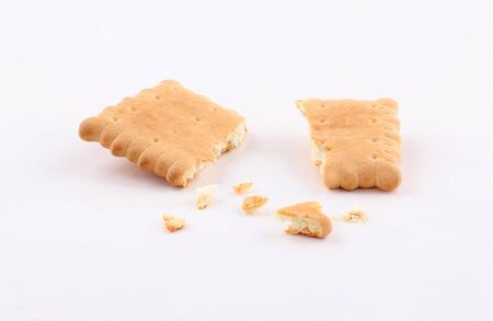 golden biscuits and sprinkled crumbs isolated on white backgroundの写真素材